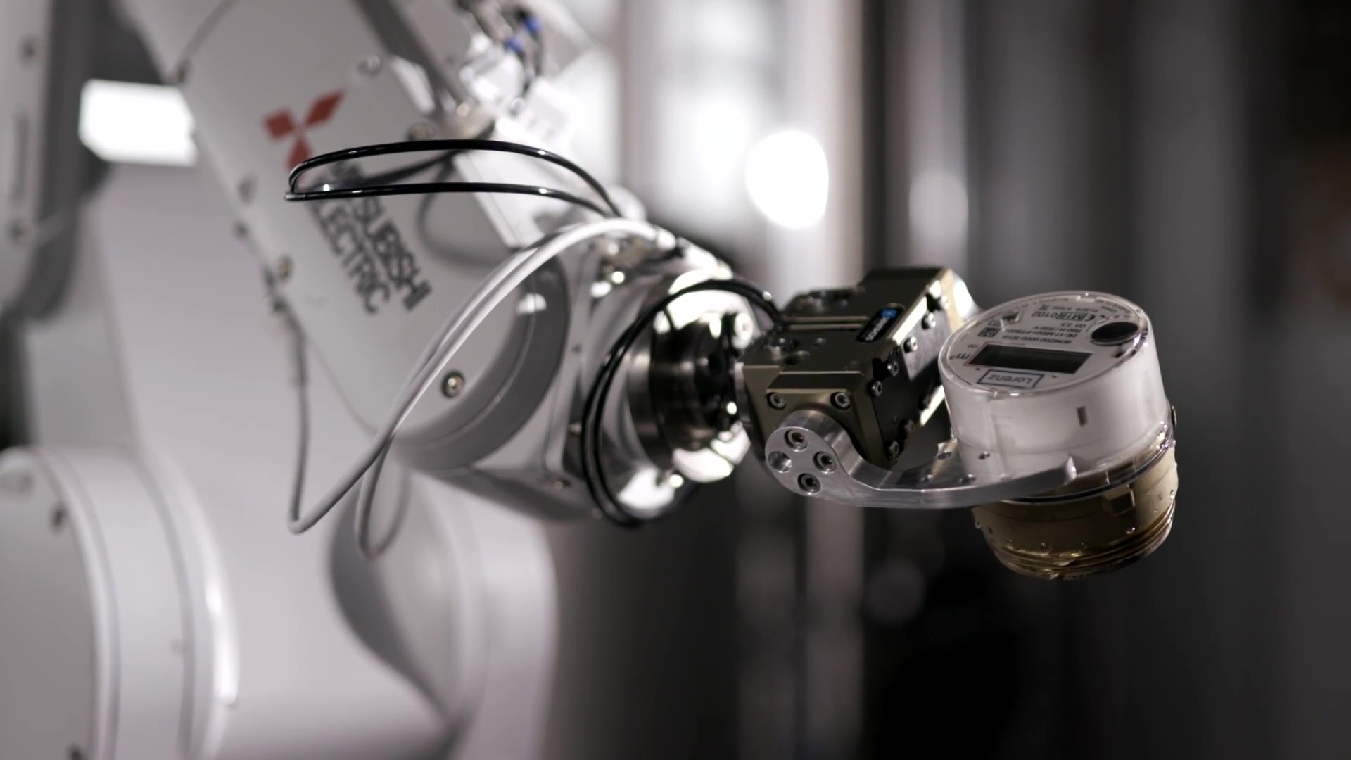 Bild zeigt Roboterarm bei der Bearbeitung eines Smart Meters